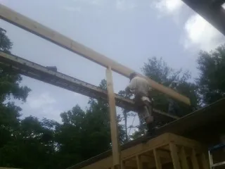 Carpenter setting a ridge beam over a new addition frame — Ice Dam Removal by Roofing Brothers in Carlton