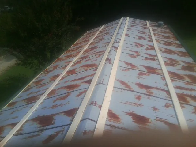 Rusted metal roof panels with new wood purlins before replacement — Storm Damage Roof Repair in Carlton by Roofing Brothers